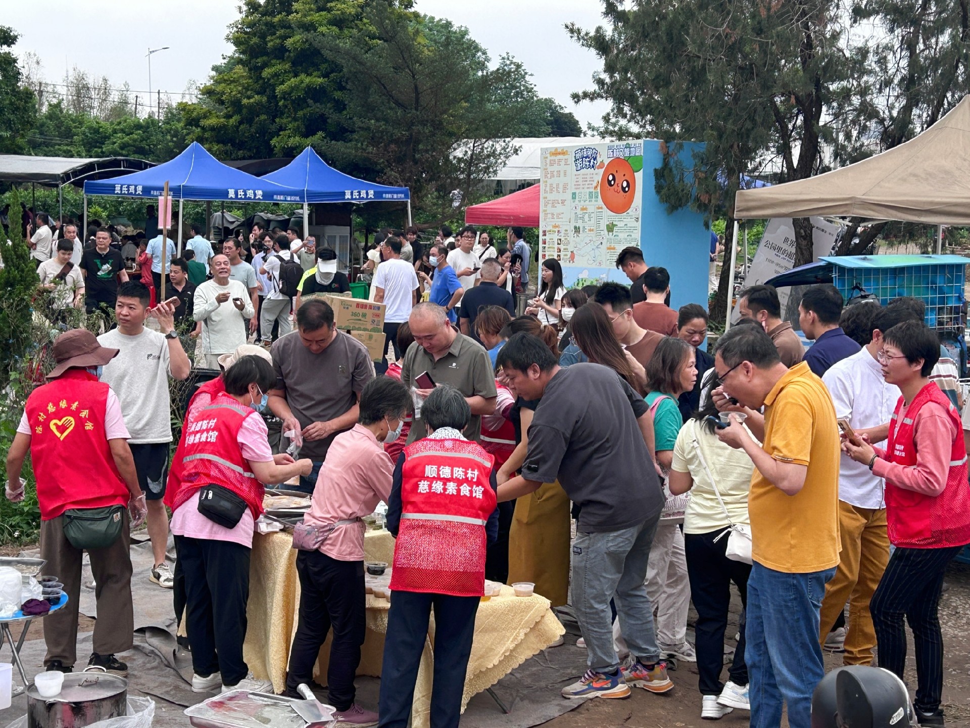 图为莫氏鸡煲店附近,义工们为游客免费赠送甜品小吃。兰航宇摄